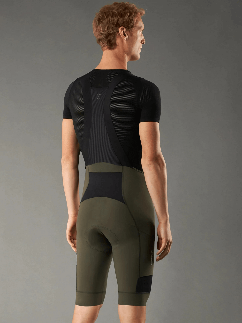 Man wearing cycling bib shorts with 3D shockproof sponge pad for long rides and performance enhancement.