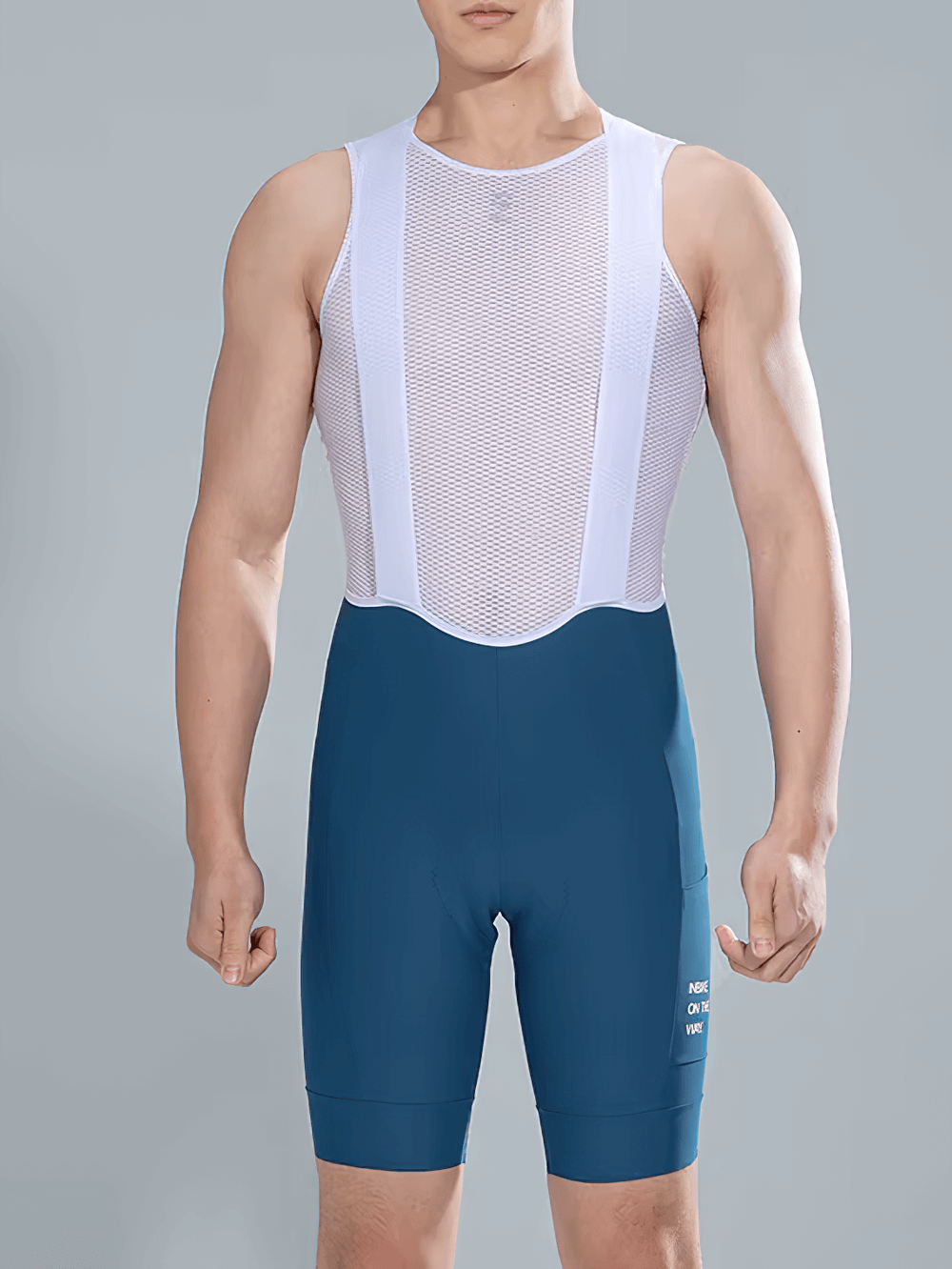 Man wearing blue cycling bib shorts with a white mesh top, featuring ergonomic padding and side pockets for long rides.