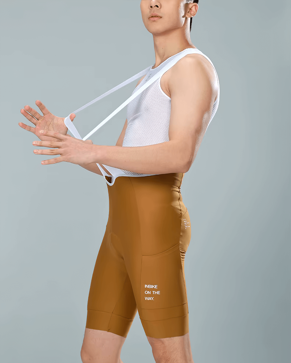 Man wearing brown Cycling Bib Shorts with Padding and Side Pockets, showcasing elastic straps for secure fit, SF2591.