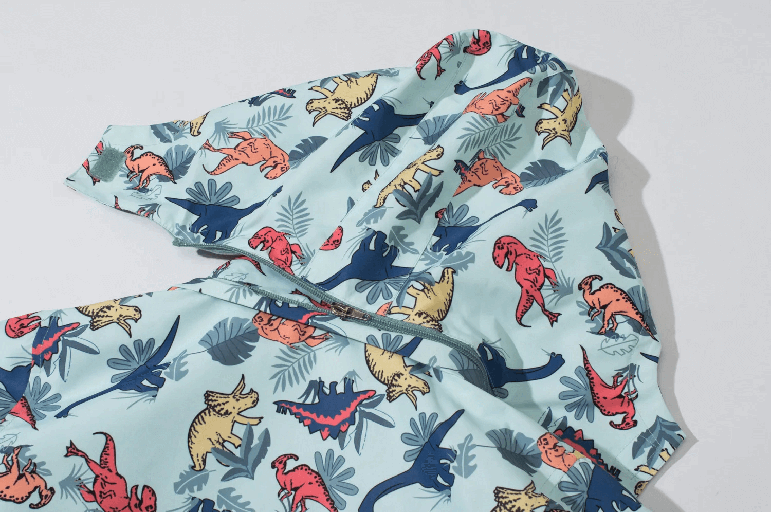 Fun dinosaur print on the Dinosaur Print Kids Waterproof Jacket with Hood - SF3577, featuring a cozy fleece lining and detachable hood.