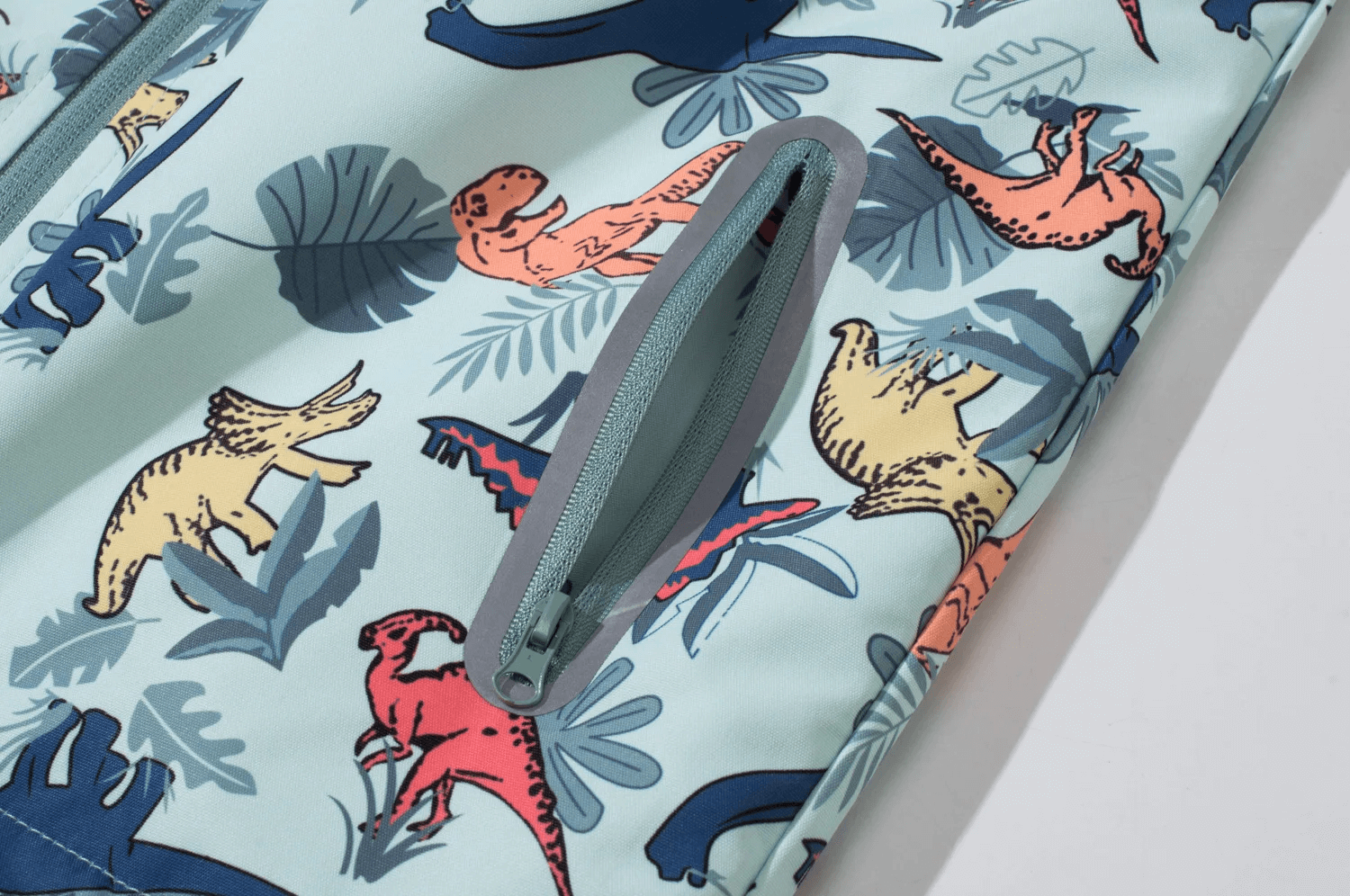 Close-up of Dinosaur Print Kids Waterproof Jacket with Hood - SF3577, featuring a colorful dinosaur pattern and waterproof zipper.