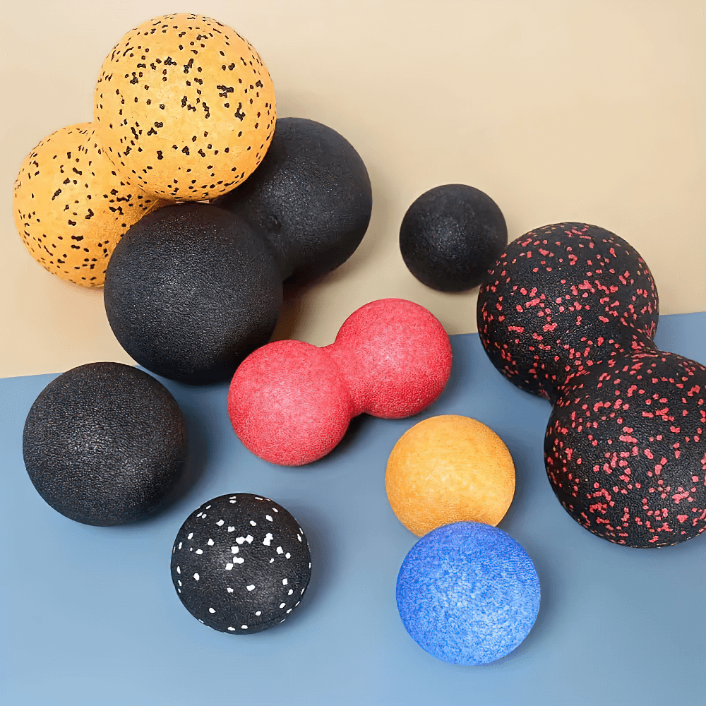 Colorful massage balls, including a double-sided red massage ball for muscle relief and tension, displayed on a beige and blue background.
