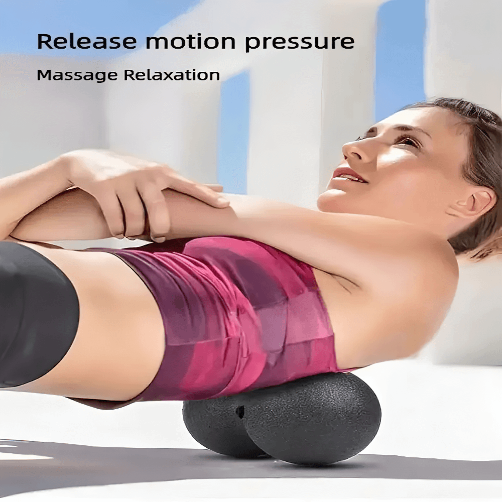 Woman using a double-sided massage ball for muscle relief and tension release on her back outdoors.