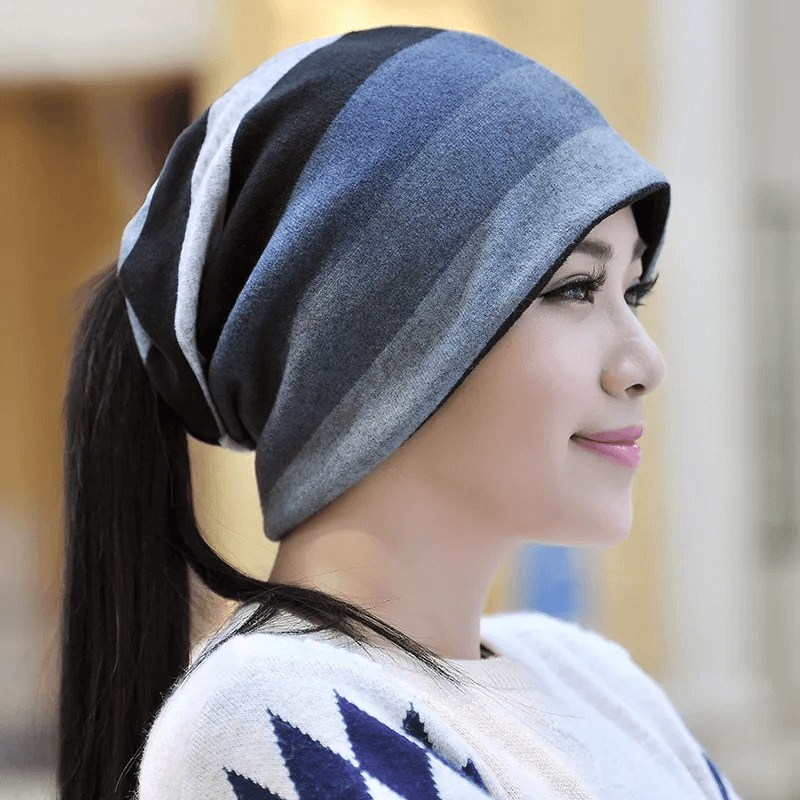 Woman wearing a dual-use striped beanie in blue and gray for a stylish and warm look. Made from soft polyester. SF1648 model.