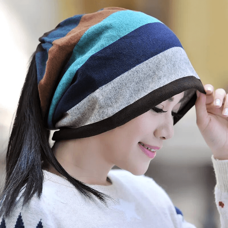 Woman wearing a stylish dual-use striped beanie made of soft polyester, showcasing a trendy and practical fashion accessory.