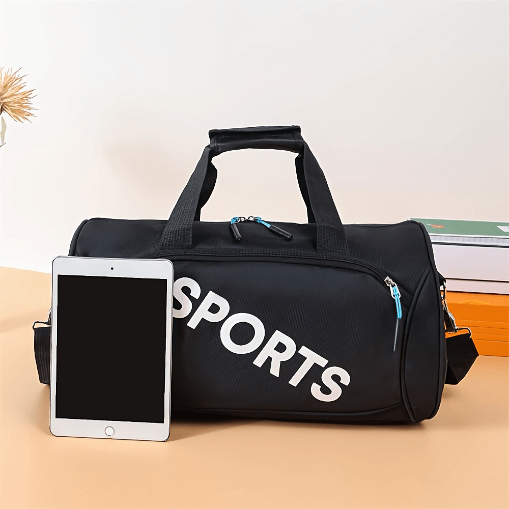 Black sports duffel bag with 'SPORTS' print and tablet, featuring secure zipper and versatile carrying options for gym or travel.