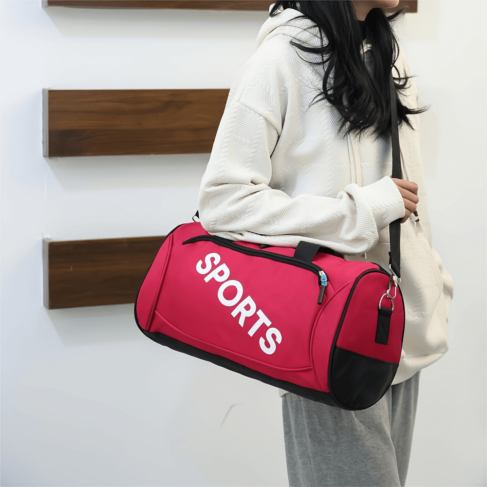 Pink Oxford fabric sports duffel bag with bold 'SPORTS' print, secure zipper, and crossbody strap. Ideal for gym or travel.