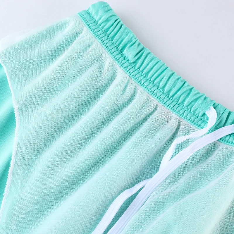Mint-green mesh shorts with white drawstring, featuring an elastic waistband for comfort and style.