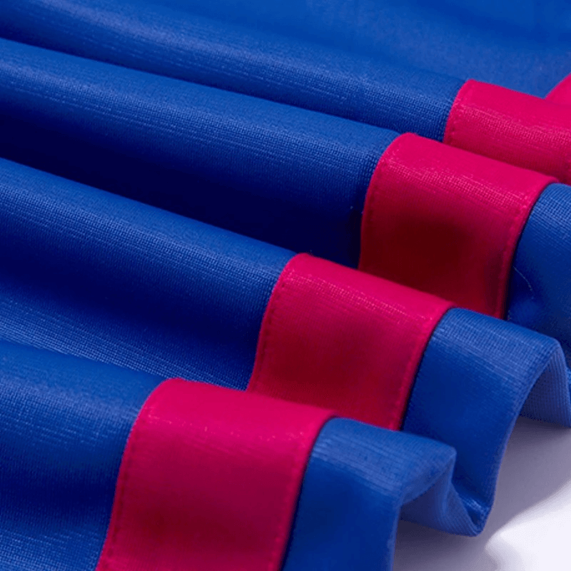 Close-up of blue fabric with vibrant red trim on breathable polyester-spandex running jacket.