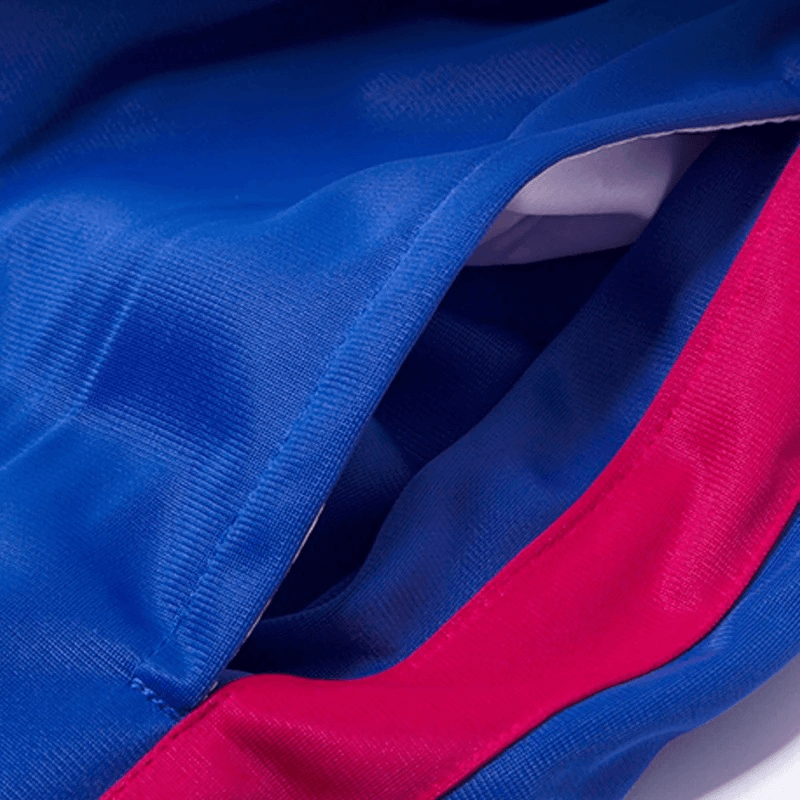 Close-up of blue and red elastic breathable men's running jacket fabric showing texture and color contrast.