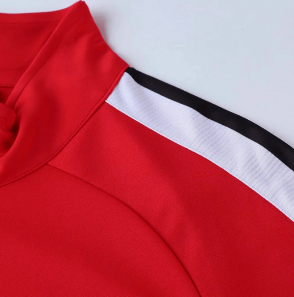 Close-up of a red sports jacket with a white and black stripe on the shoulder, highlighting the breathable and durable material.