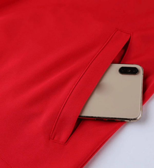Red men's sports jacket with a pocket holding a smartphone, showcasing breathable fabric and sleek design.
