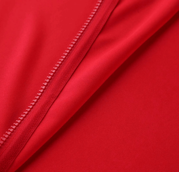 Close-up of red elastic breathable sports jacket with zipper detailing.