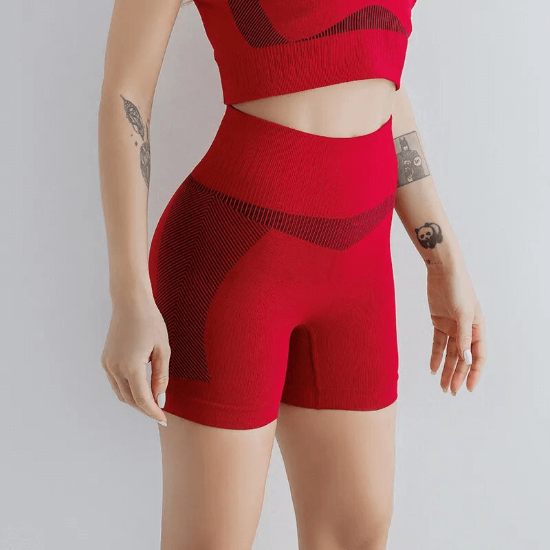 Woman wearing red elastic breathable high-waisted shorts for yoga or running. SF1614 model, comfy fit with stretchy waistband. Perfect for workouts.
