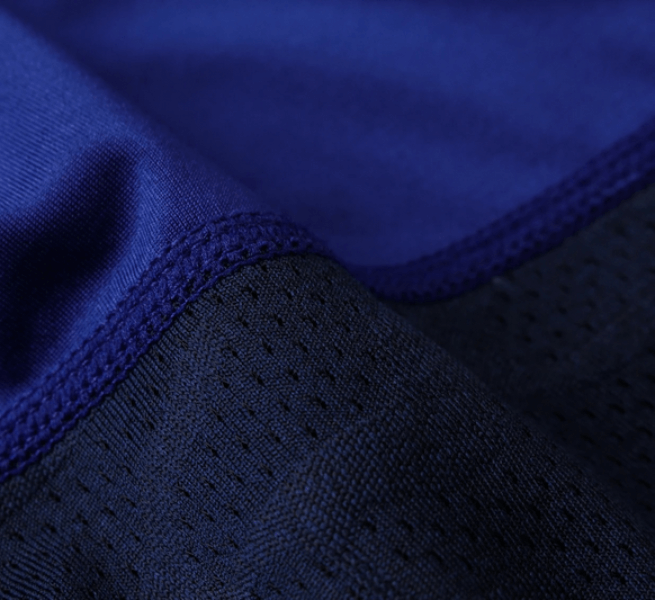Close-up of blue and black fabric on men's compression leggings, highlighting texture and stitching details.