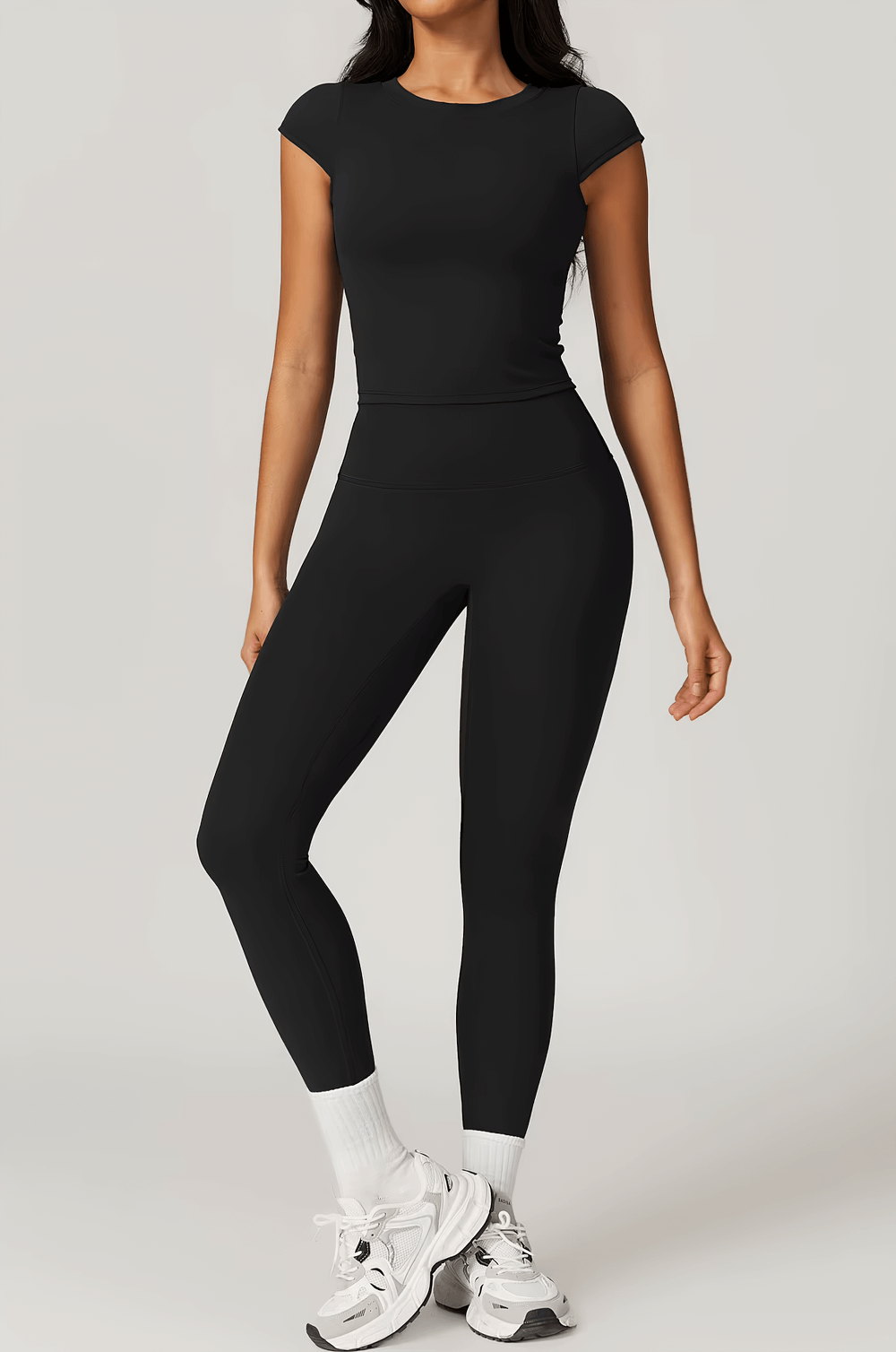Woman wearing black elastic short sleeve sport T-shirt and leggings, perfect for yoga, running, and hiking. SF2420.