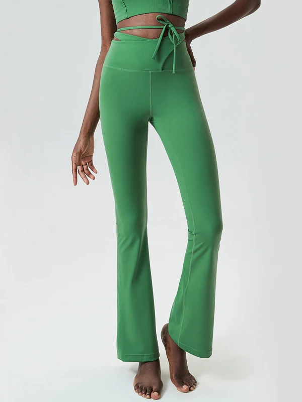 Emerald green flare yoga pants with tie waist detail, perfect for stylish workout fashion.