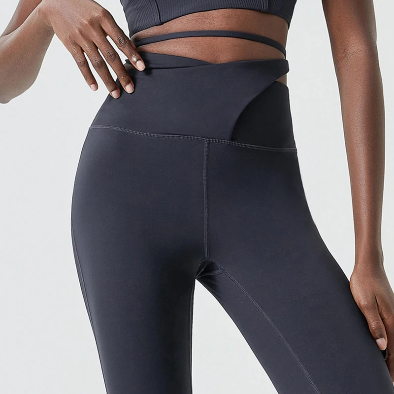 Close-up of elegant black flare yoga pants with tie waist detail, showcasing stylish fitness wear for modern, fashion-forward individuals.
