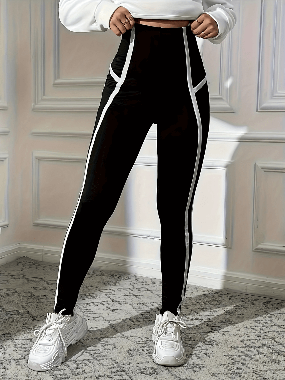 Woman wearing high-waisted sports leggings with side stripes, ideal for yoga and workouts.