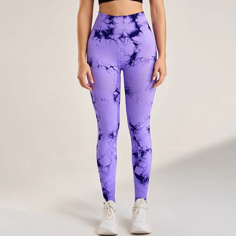 Woman wearing purple tie-dye high-waisted seamless yoga leggings, perfect for fitness routines, made from Lycra and Nylon.