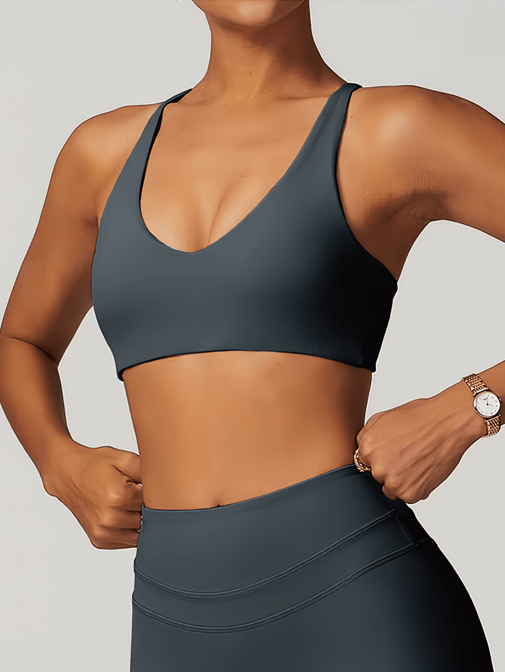 Woman wearing elastic racerback sports bra top for fitness, designed for yoga, running, and dancing with breathable, quick-dry fabric.