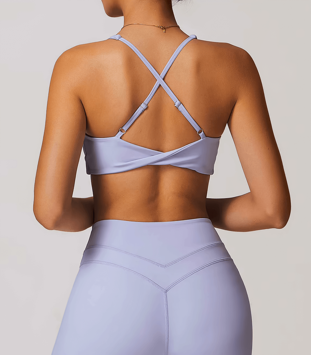 Back view of a woman wearing a lilac racerback sports bra and leggings, ideal for yoga and high-intensity workouts.