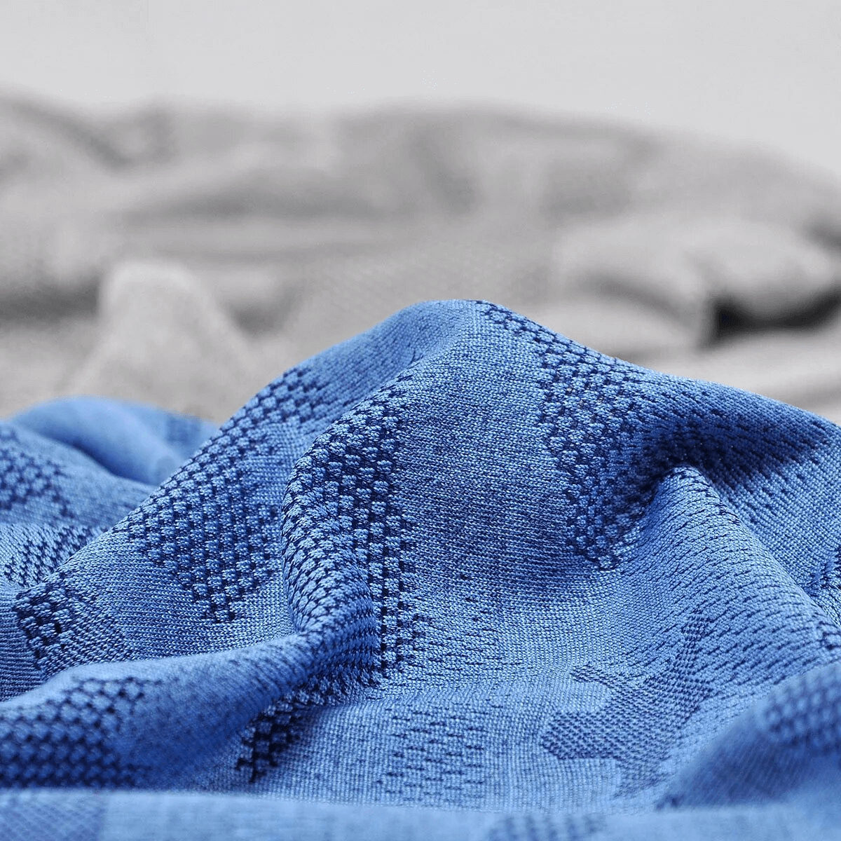 Close-up of blue geometric patterned elastic baggy beanie fabric for men and women, made with cotton and polyester blend.