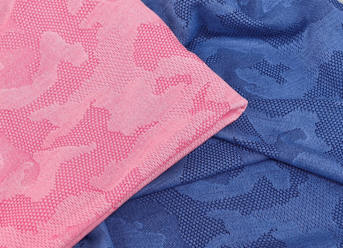 Close-up of pink and blue geometric fabric from elastic soft baggy beanie, highlighting texture and pattern for fashion enthusiasts.