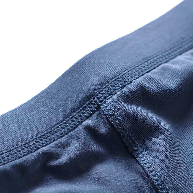 Close-up of elastic soft men's blue boxers with solid pattern, showcasing moisture-wicking and breathable fabric for ultimate comfort.