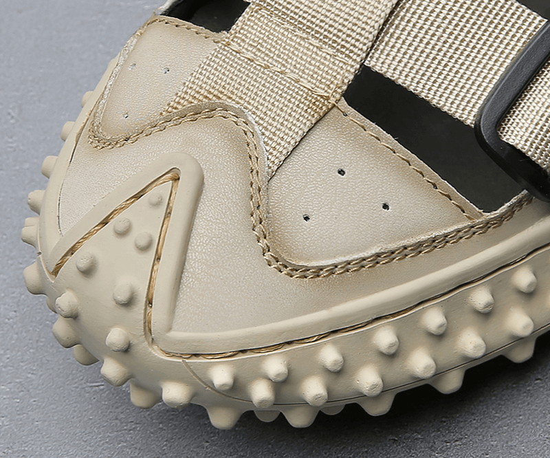 Close-up of elastic soles on leather men's hiking sandal with breathable upper, featuring robust grip and comfort for outdoor adventures.