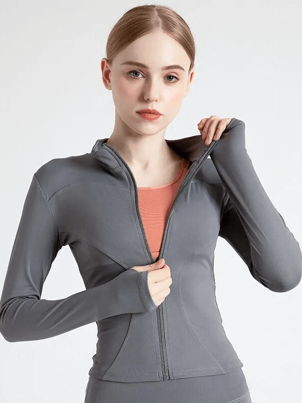 Woman wearing gray Elastic Sports Jacket with zipper and finger holes, ideal for running, made from breathable, waterproof fabric.
