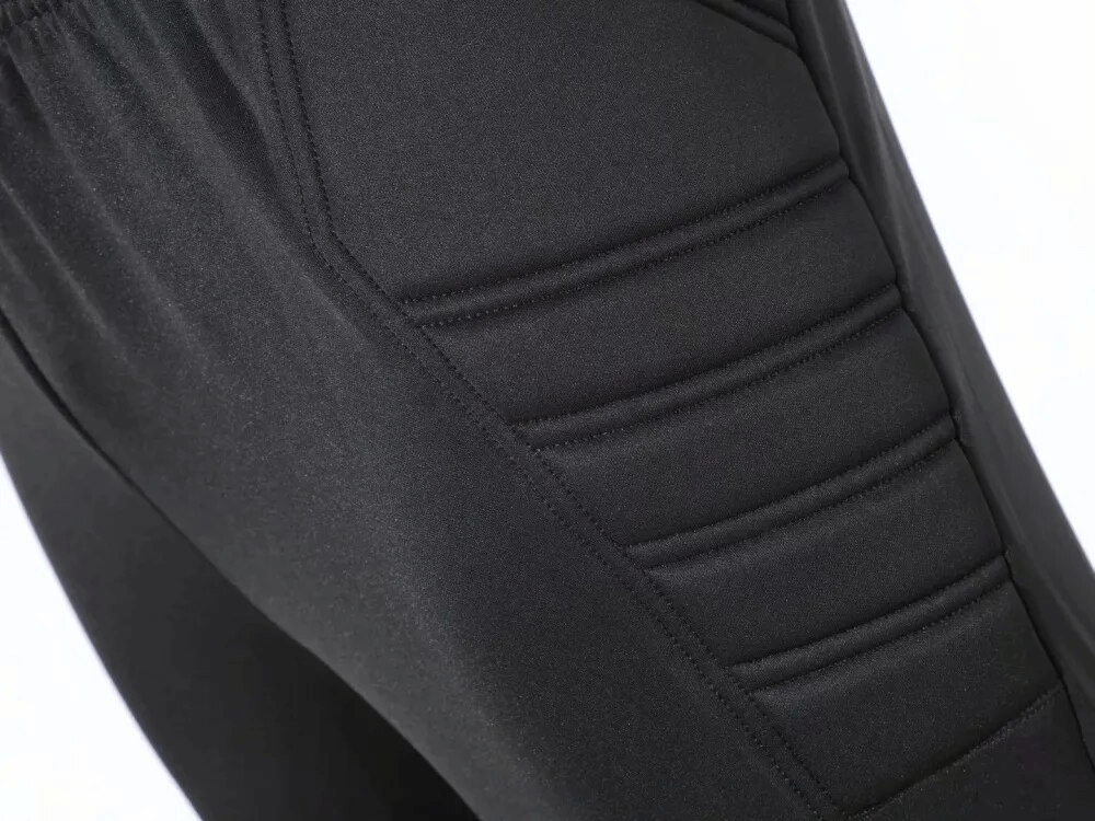 Close-up of black elastic waist men's training pants with protective padding, showcasing high-quality polyester fabric.