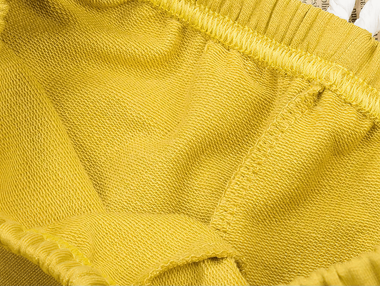 Close-up of Elastic-Waist Solid Shorts With Drawstring Detail - SF3725 showing yellow soft cotton fabric and elastic waistband for kids.