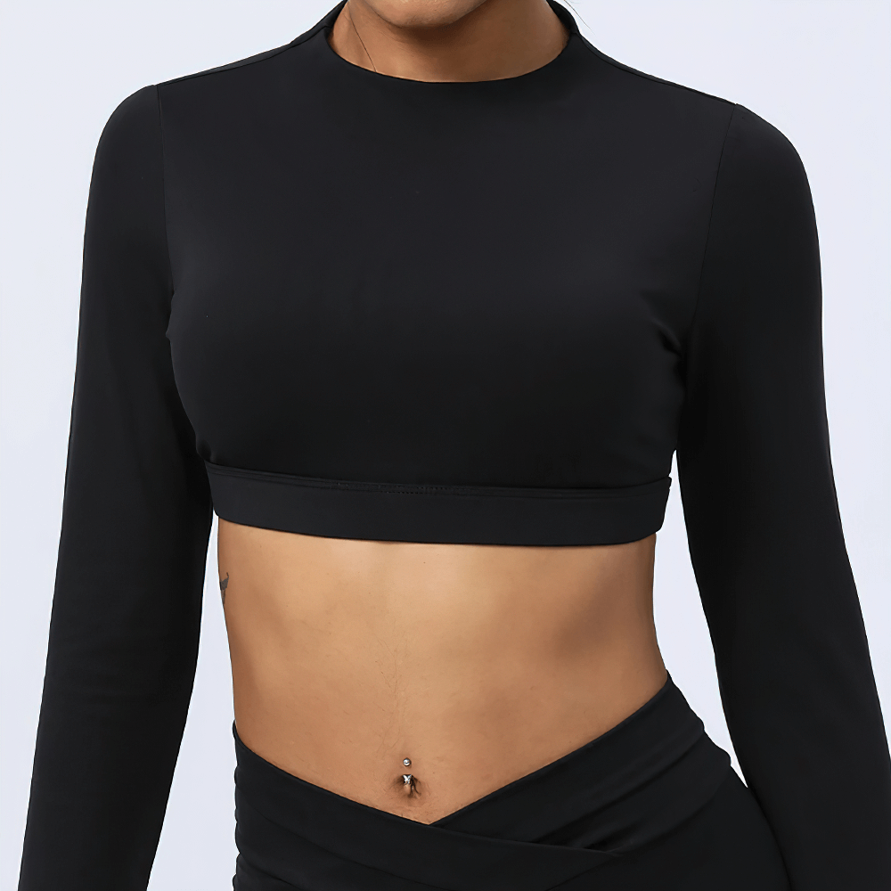 Woman wearing elegant cut-out back yoga top in black, showcasing stylish fitness wear designed for breathability and flexibility.