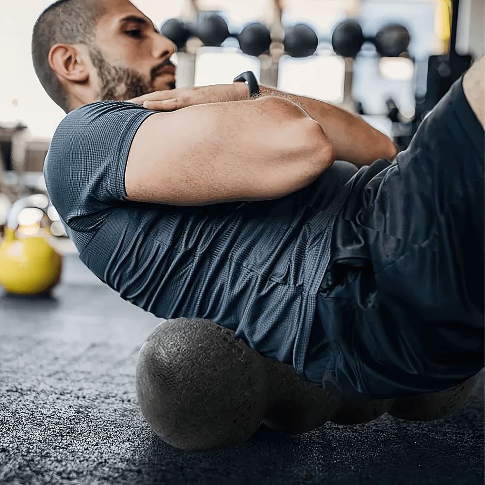 Man using EPP peanut massage roller for back therapy in gym setting, enhancing muscle recovery and relief.