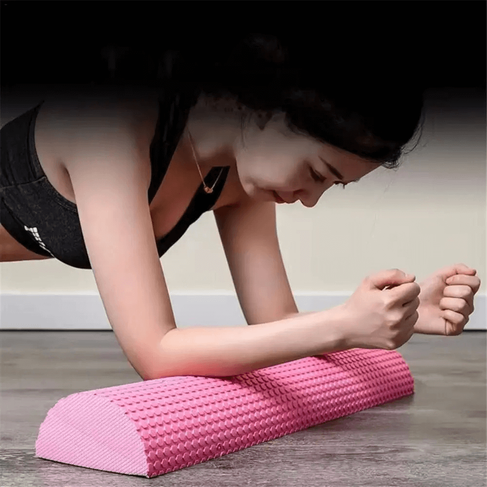 Woman using pink foam roller for workout on floor
