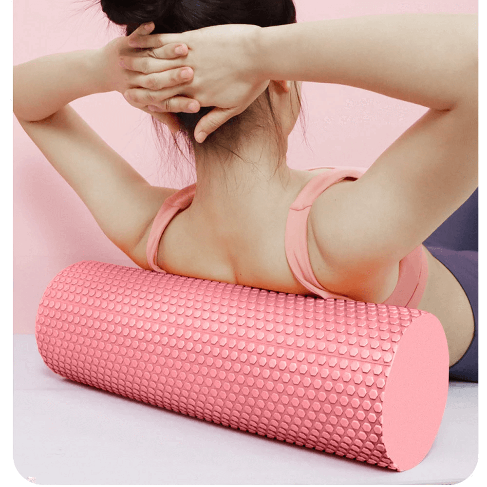 Person using pink hexagonal EVA foam roller for back massage and muscle relief.