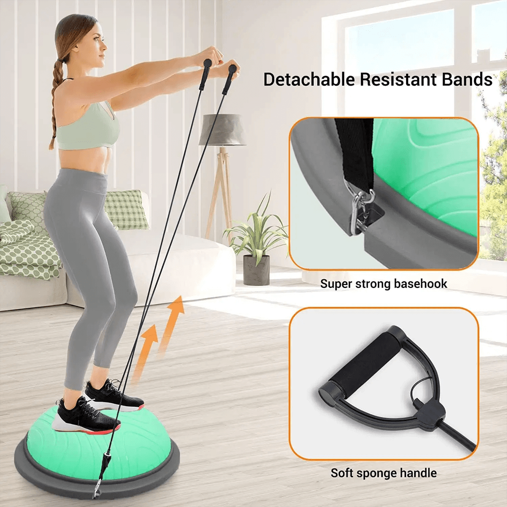 Woman exercising on a green balance ball trainer with resistance bands in a living room setting.