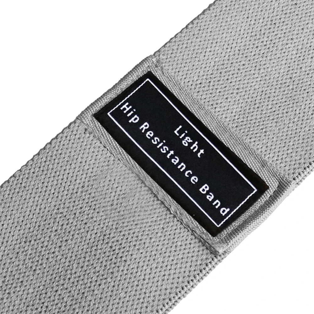 Close-up of a light grey fabric hip resistance band with label, ideal for glute activation and thigh workouts.