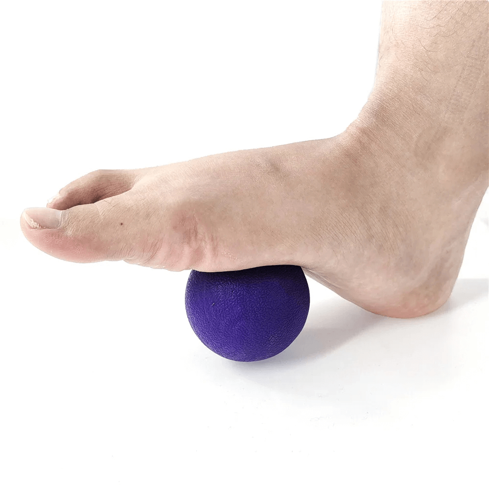 Foot using purple fascia massage ball for muscle relaxation and pain relief.