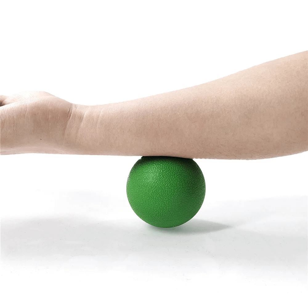 Person using green fascia ball for arm muscle relaxation and pain relief, demonstrating targeted massage technique.