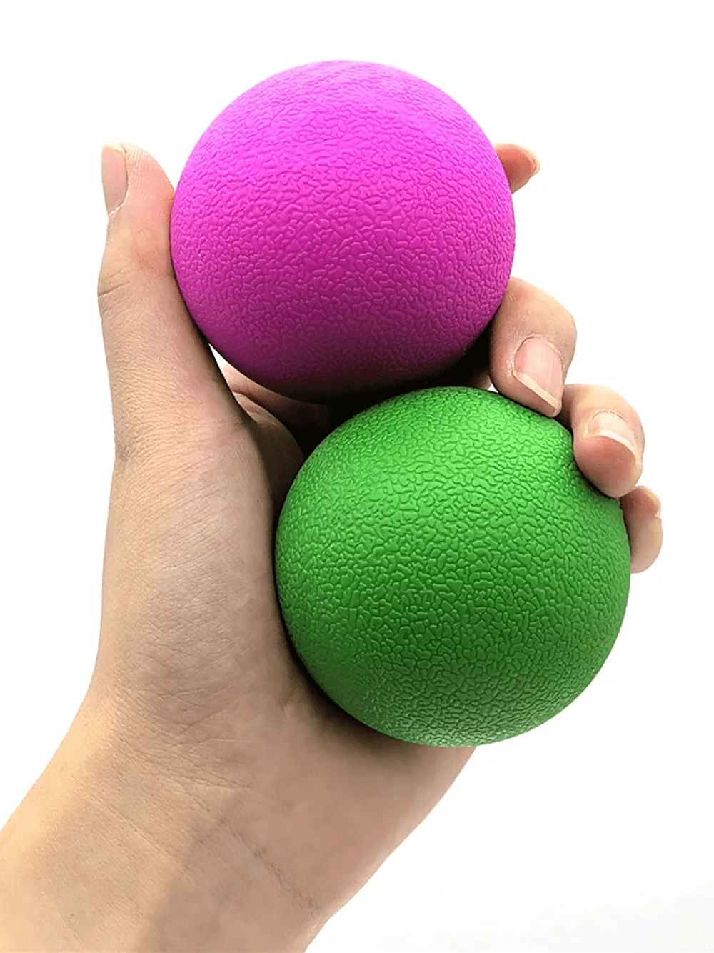 Hand holding pink and green fascia massage balls for muscle relaxation and pain relief, ideal for stress relief and trigger point therapy.