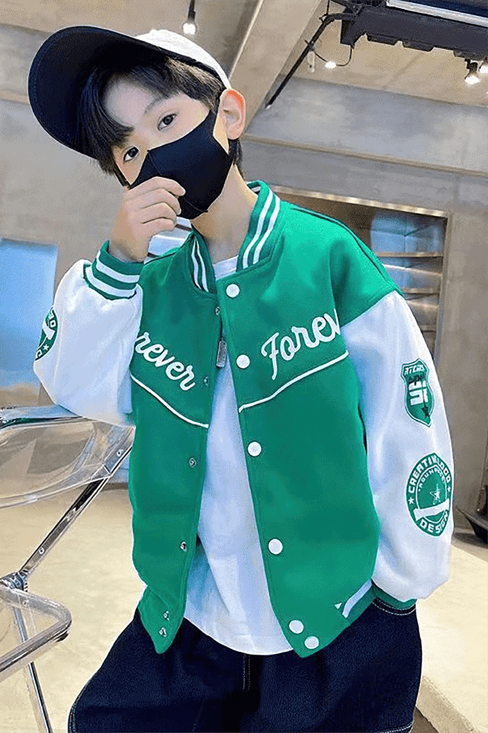 Young boy wearing a stylish green baseball jacket and cap, embodying sporty spring fashion for kids aged 3 to 14.