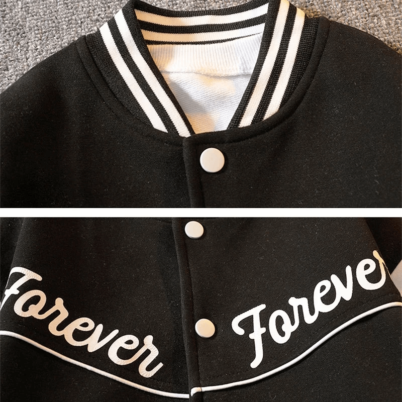 Close-up of a kids' black baseball jacket with "Forever" text, featuring striped collar and button detail, ideal for boys' sports fashion.