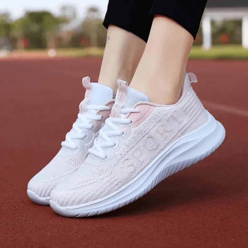 Woman wearing Fashion Breathable Walking Running Shoes SF1735 in pink on track. Lightweight, flexible, non-slip for optimal comfort. 