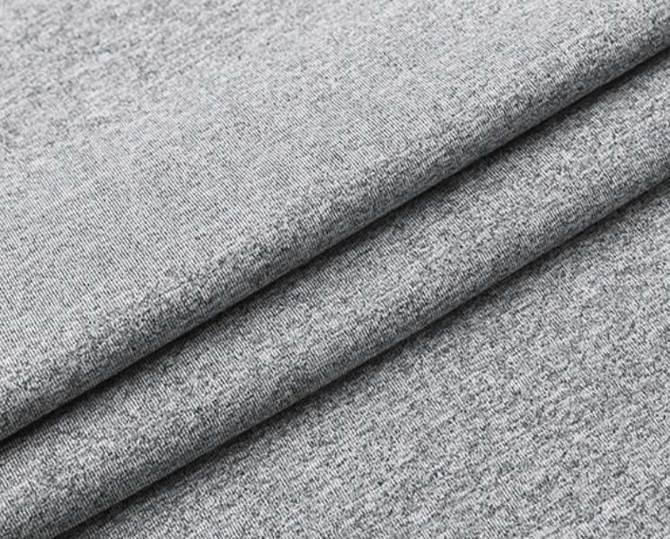 Close-up of folded grey polyester-spandex fabric, highlighting soft texture and weave, perfect for men's t-shirt.