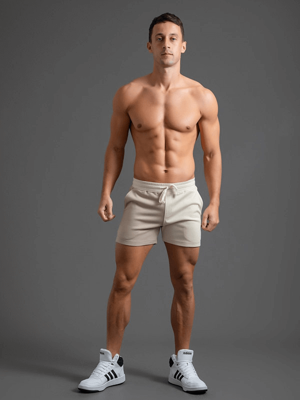 Man wearing fashion elastic waist cotton shorts, showcasing mid-waist drawstring design and patchwork style for a sporty look.