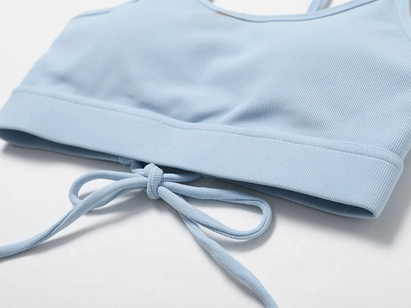 Light blue seamless sports bra with tie detail, crafted from breathable and quick-dry fabric, ideal for running and fitness activities.