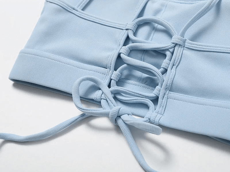 Close-up of blue seamless sportswear top with stylish lacing, featuring breathable and quick-dry fabric for ultimate comfort.