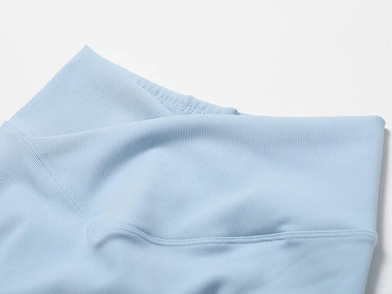 Close-up of light blue seamless fabric from Fashion Female 2pcs Sports Set, highlighting smooth texture and breathable material.